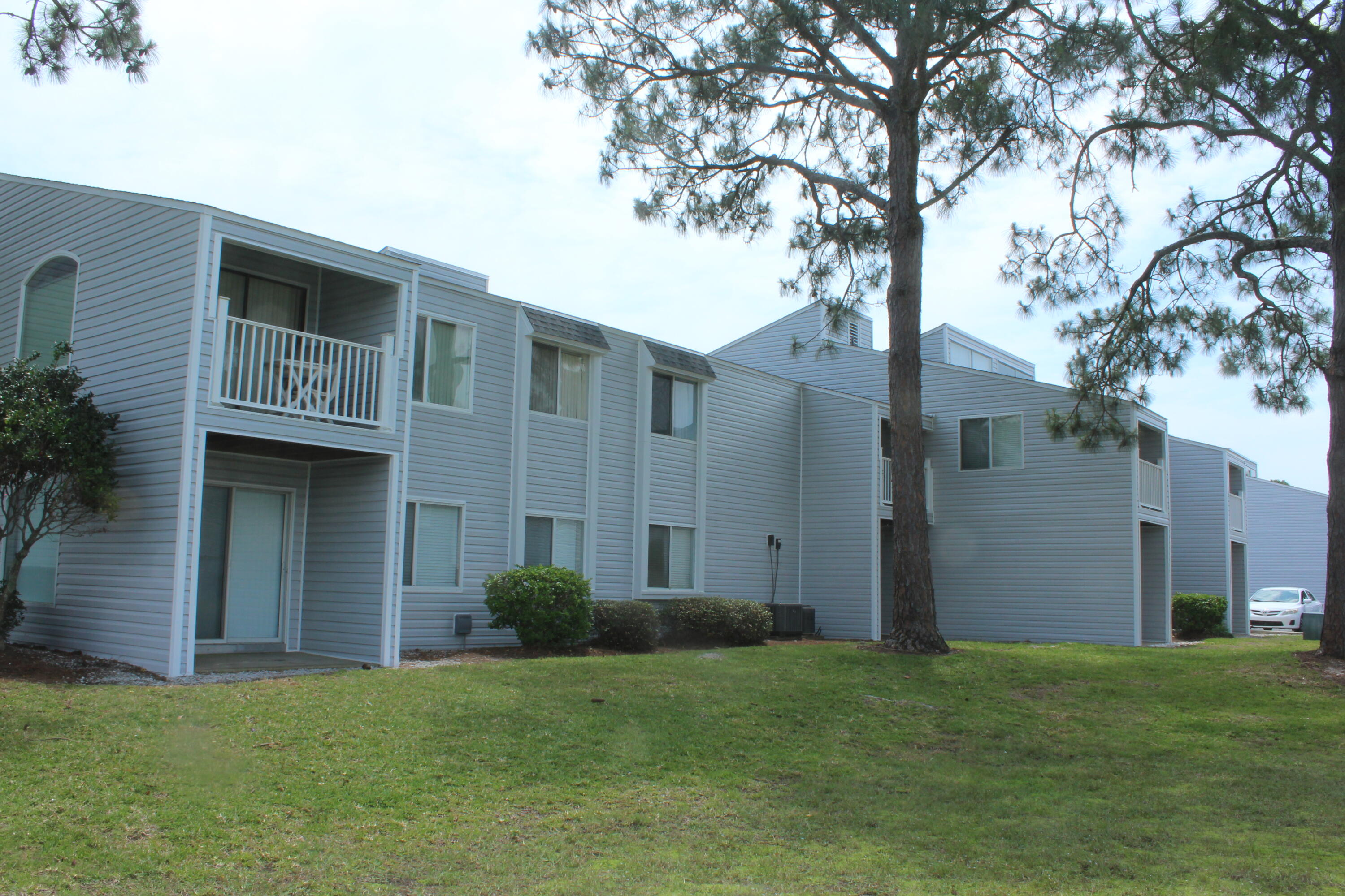101 Old Ferry Road, Unit 29C Shalimar, FL 32579 - Photo 7 of 30 a backyard of a house with plants and large tree