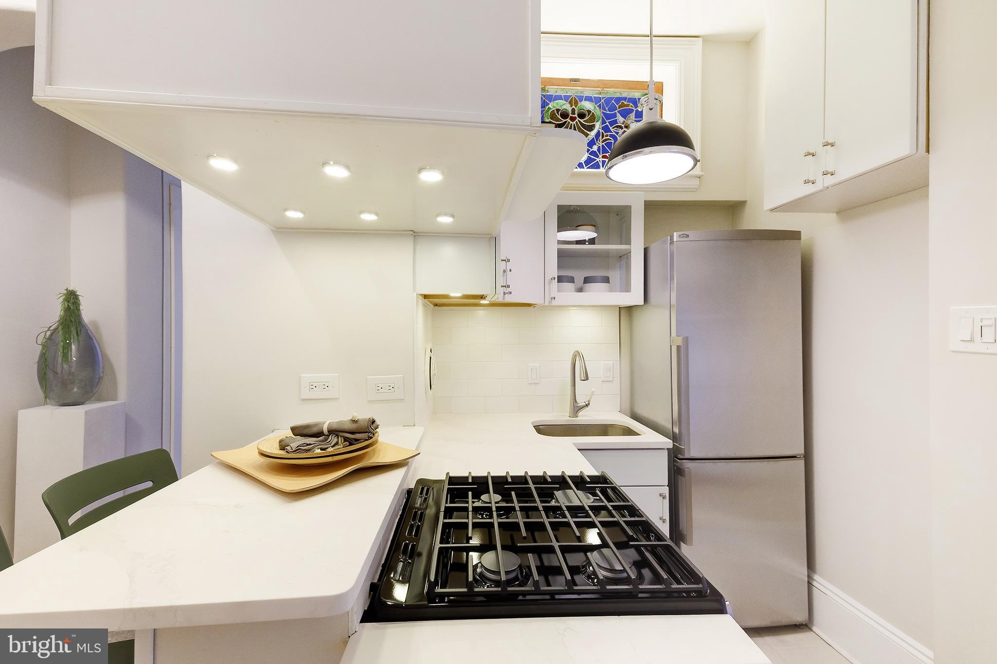 2853 Ontario Road Northwest, Unit 107 Washington, DC 20009 - Photo 11 of 39 a kitchen with stainless steel appliances granite countertop a sink stove and refrigerator