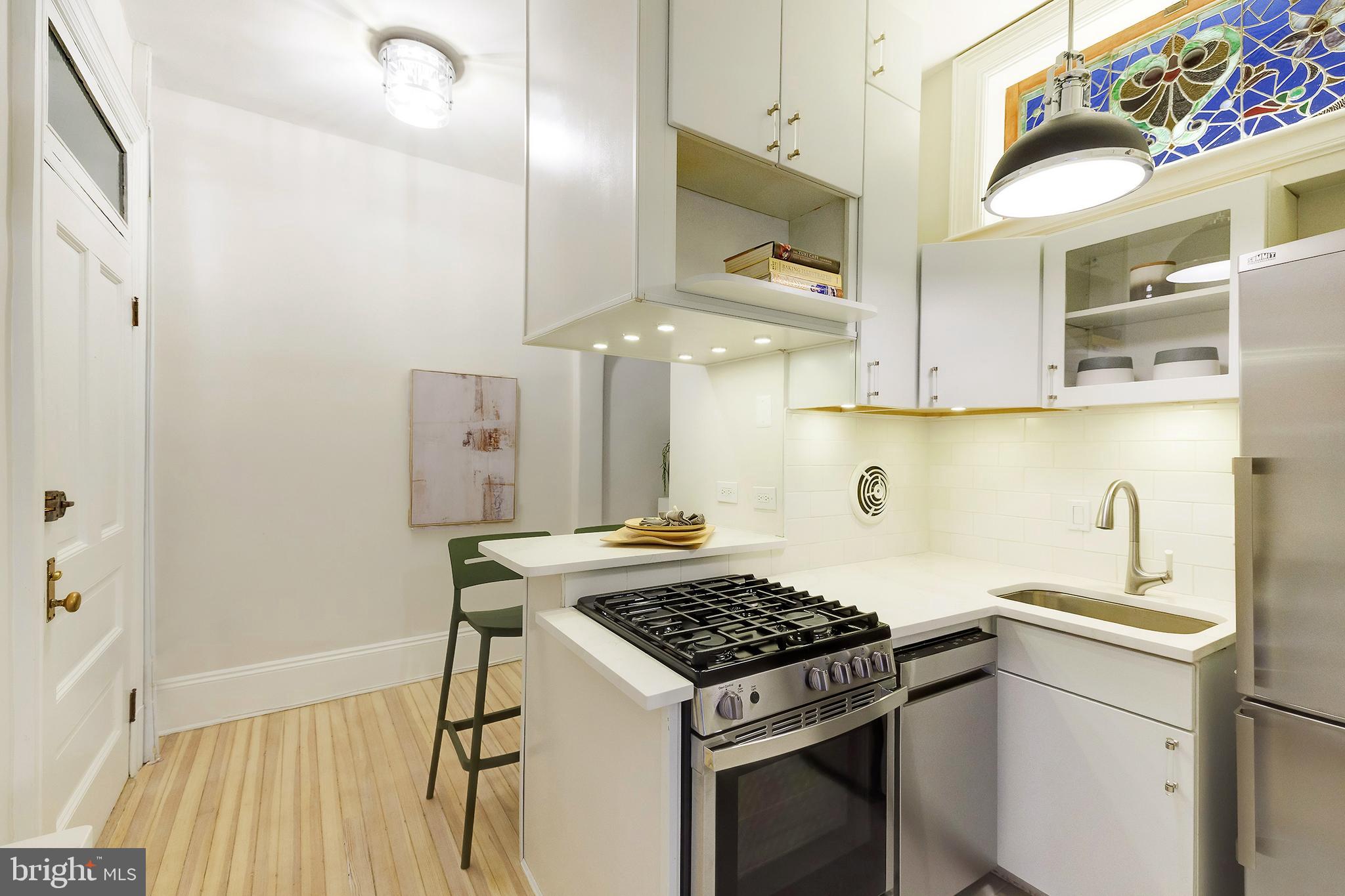 2853 Ontario Road Northwest, Unit 107 Washington, DC 20009 - Photo 9 of 39 a kitchen with stainless steel appliances granite countertop a sink stove and refrigerator