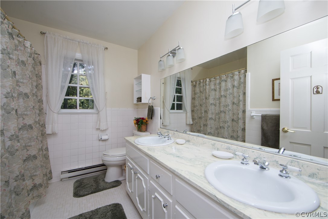 2729 West Brigstock Road Midlothian, VA 23113 - Photo 34 of 50 a bathroom with a double vanity sink toilet and shower