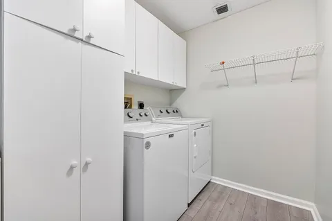 a utility room with cabinets washer and dryer