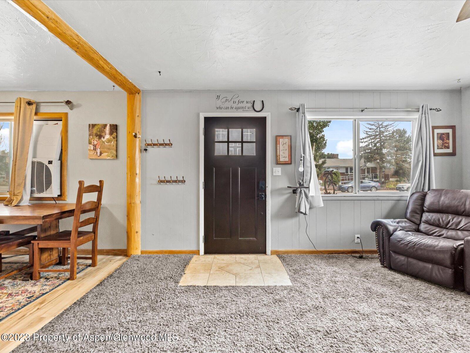 455 Elm Avenue Rifle, CO 81650 - Photo 5 of 25 a living room with a couch and a dining table next to a window