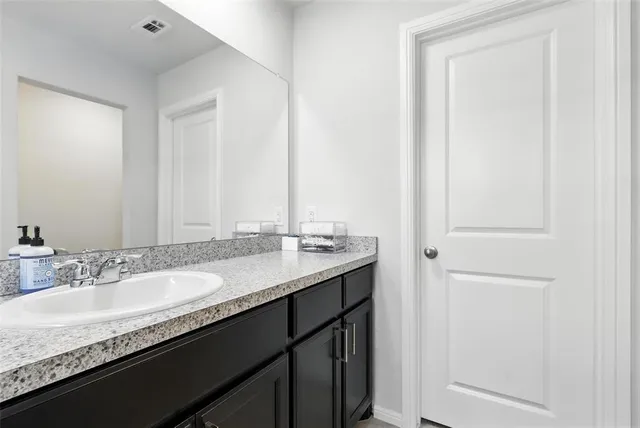 a bathroom with a granite countertop sink and a mirror