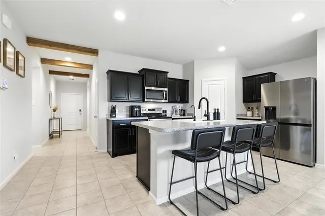 a kitchen with stainless steel appliances granite countertop a refrigerator and a stove top oven