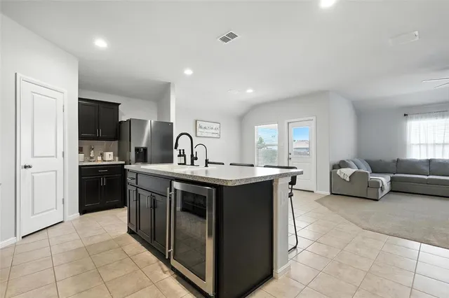 a kitchen with kitchen island granite countertop a sink and a stove top oven with wooden floor