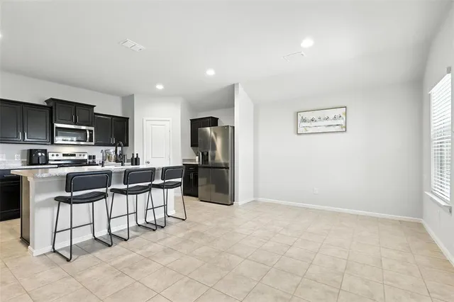 a kitchen with stainless steel appliances kitchen island granite countertop a refrigerator and cabinets