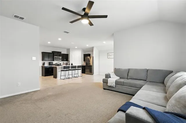 a living room with furniture and kitchen view