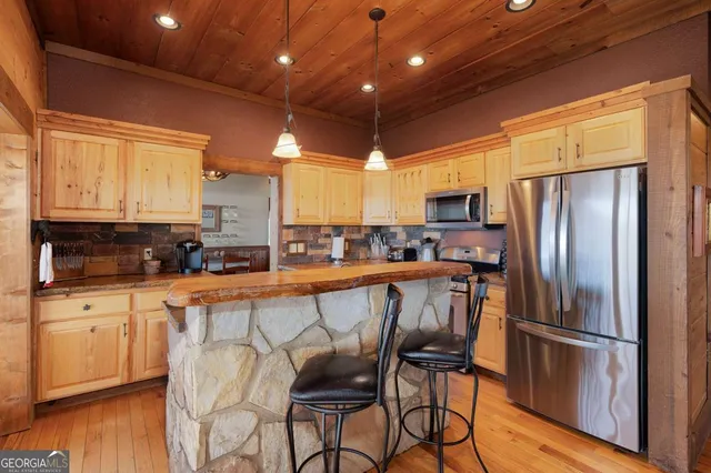 a kitchen with stainless steel appliances granite countertop a stove a sink and a refrigerator
