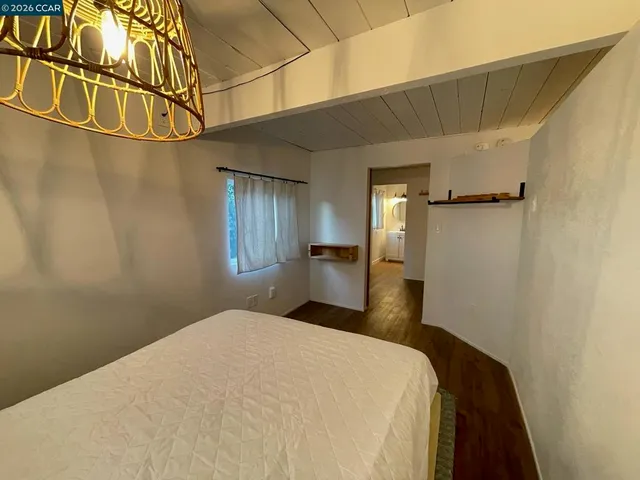 a bedroom with a bed and a wooden floor