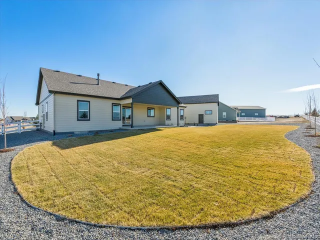 a bed sitting in a bedroom next to a large window with wooden floor