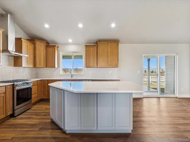 a kitchen with stainless steel appliances granite countertop a sink stove and cabinets