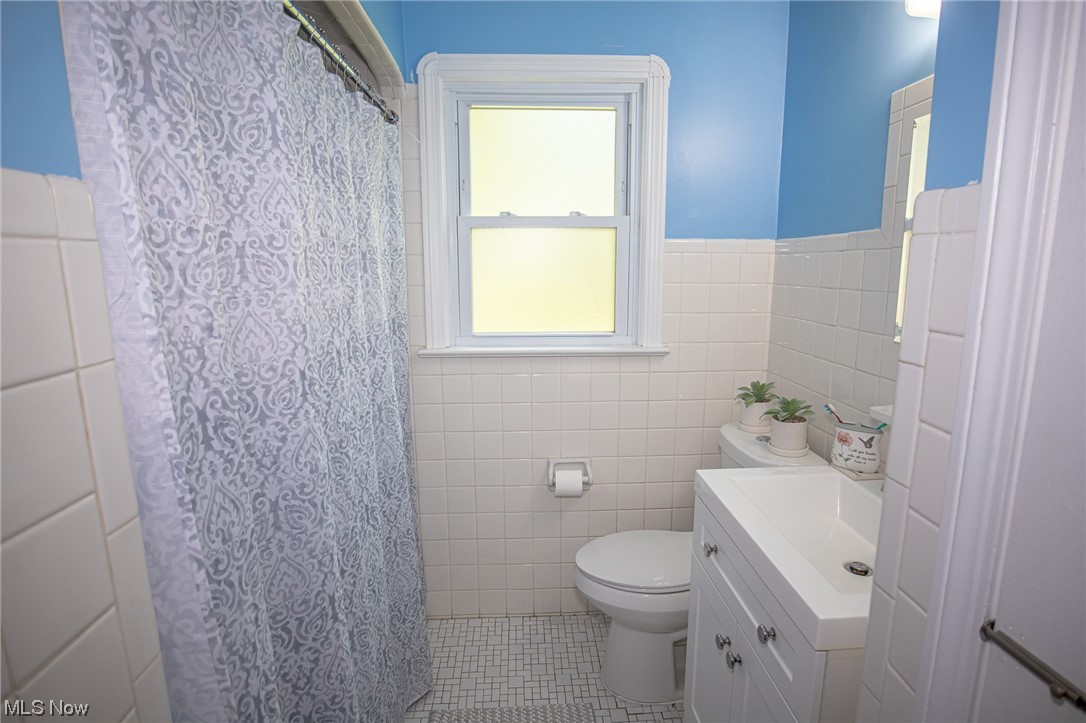 8202 Snow Road Parma, OH 44129 - Photo 12 of 29 Bathroom featuring tile floors, vanity, and tile walls