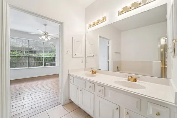 an empty room with a chandelier fan and windows