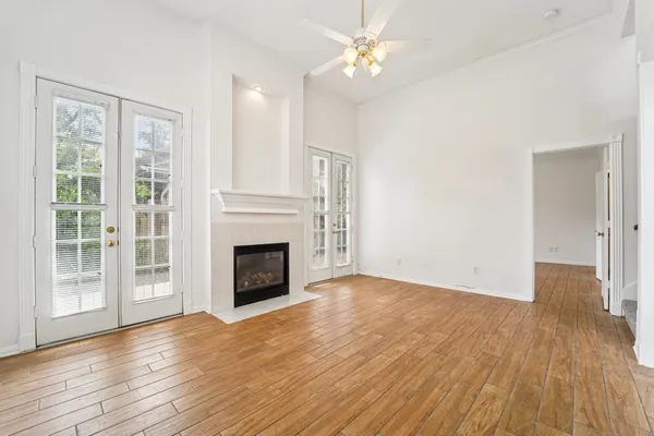 a view of a livingroom with wooden floor a fireplace and windows