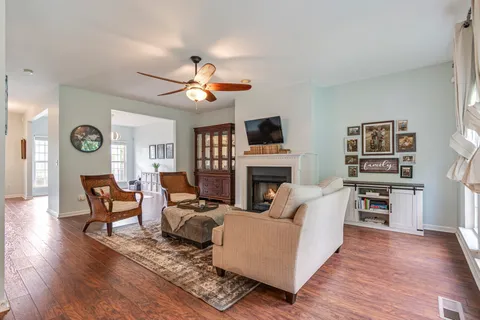 a living room with furniture a ceiling fan a rug and a window