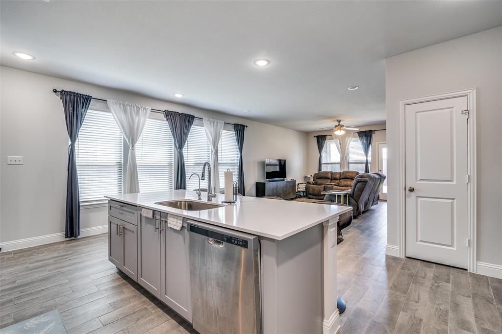 1069 Norias Drive Forney, TX 75126 - Photo 11 of 36 a open kitchen with stainless steel appliances granite countertop a sink and dishwasher with wooden floor