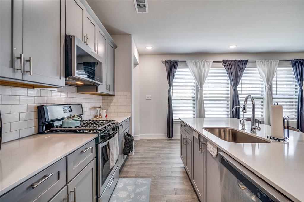 1069 Norias Drive Forney, TX 75126 - Photo 12 of 36 a kitchen with a sink stove top oven and cabinets