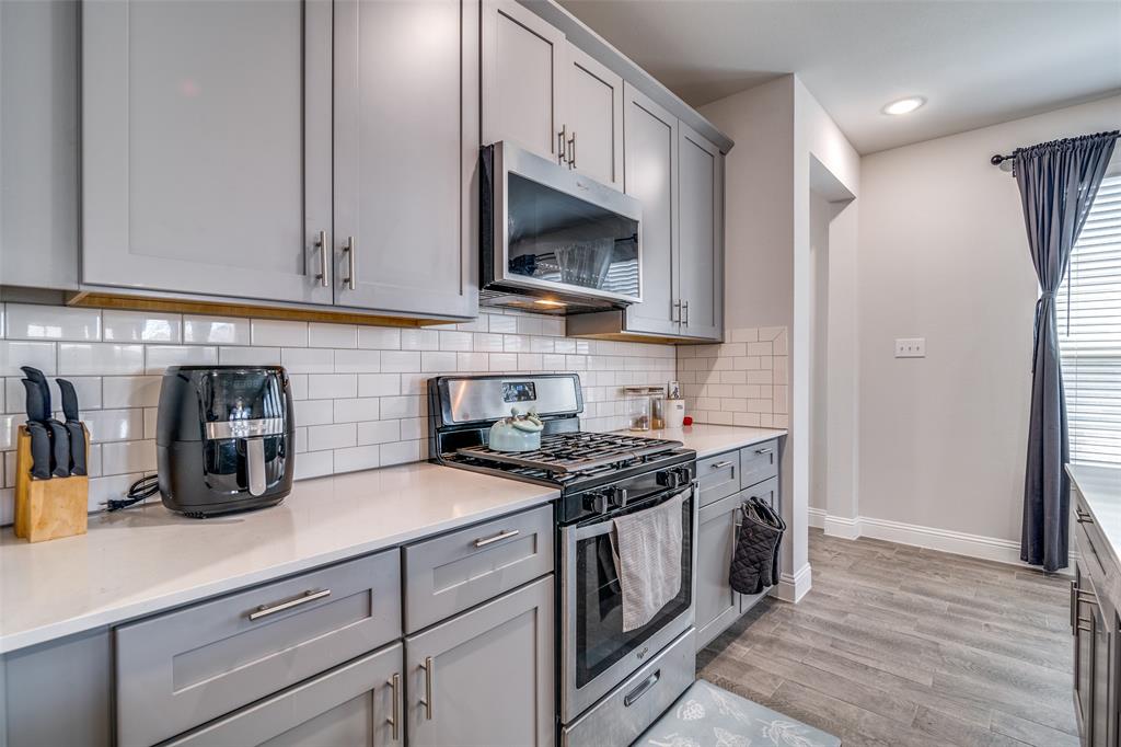 1069 Norias Drive Forney, TX 75126 - Photo 13 of 36 a kitchen with granite countertop a stove and a sink