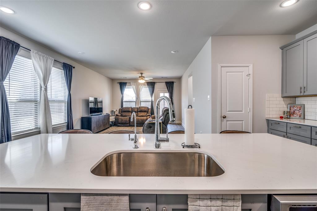 1069 Norias Drive Forney, TX 75126 - Photo 36 of 36 a kitchen with granite countertop a sink and a stove top oven