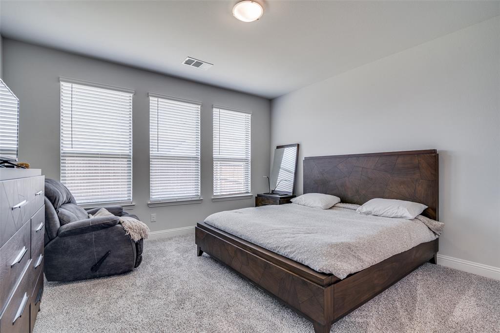 1069 Norias Drive Forney, TX 75126 - Photo 17 of 36 a large bedroom with a bed and window