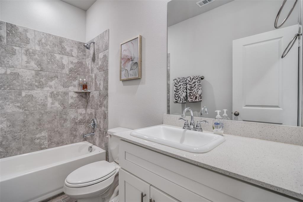 1069 Norias Drive Forney, TX 75126 - Photo 29 of 36 a bathroom with a granite countertop sink bathtub toilet and shower