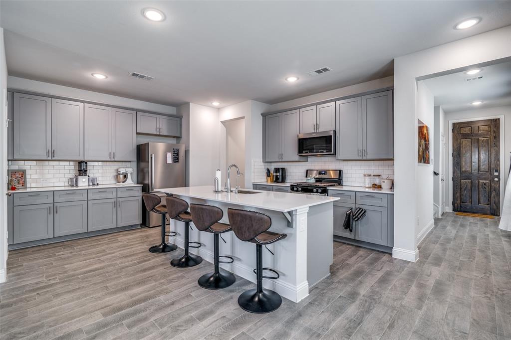 1069 Norias Drive Forney, TX 75126 - Photo 8 of 36 a kitchen with a sink a counter top space stainless steel appliances and cabinets