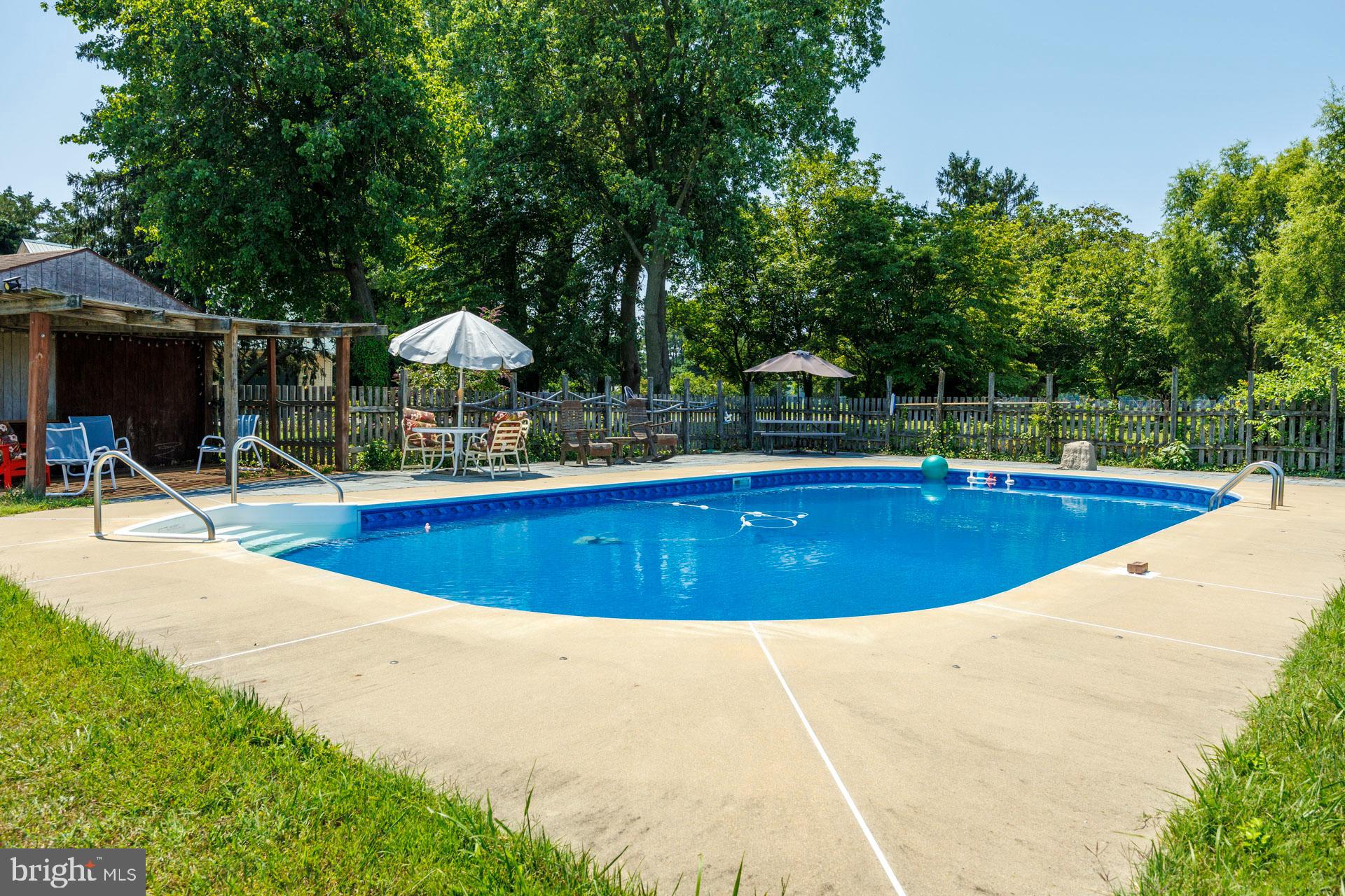 2208 Horns Point Road Cambridge, MD 21613 - Photo 13 of 39 a view of a swimming pool with a bench and trees