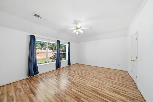 a view of a bedroom with a bed and a chandelier fan