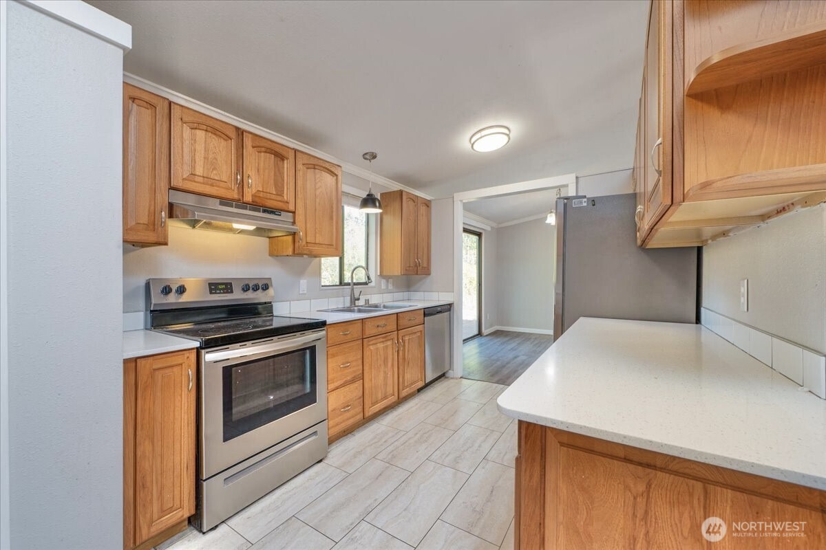 331 Frontier Road Grapeview, WA 98546 - Photo 16 of 39 a kitchen with stainless steel appliances granite countertop a sink stove and refrigerator