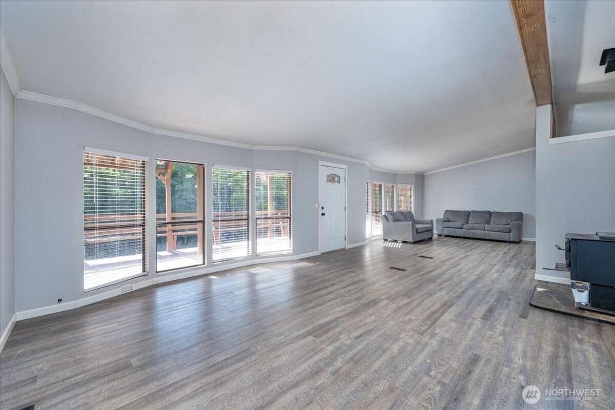 331 Frontier Road Grapeview, WA 98546 - Photo 8 of 39 a view of empty room with wooden floor and fireplace