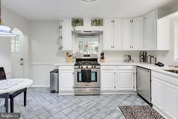 a kitchen with a refrigerator and white cabinets