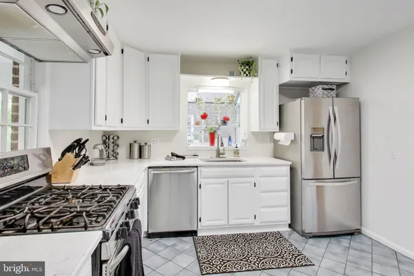 a kitchen with stainless steel appliances a stove a sink and cabinets