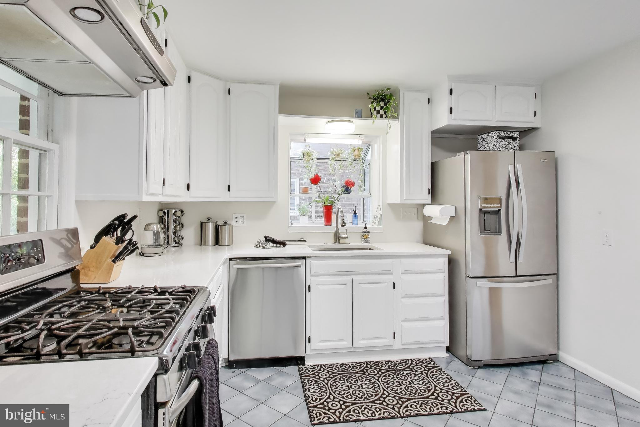 9613 Lorain Avenue Silver Spring, MD 20901 - Photo 12 of 40 a kitchen with a refrigerator and white cabinets