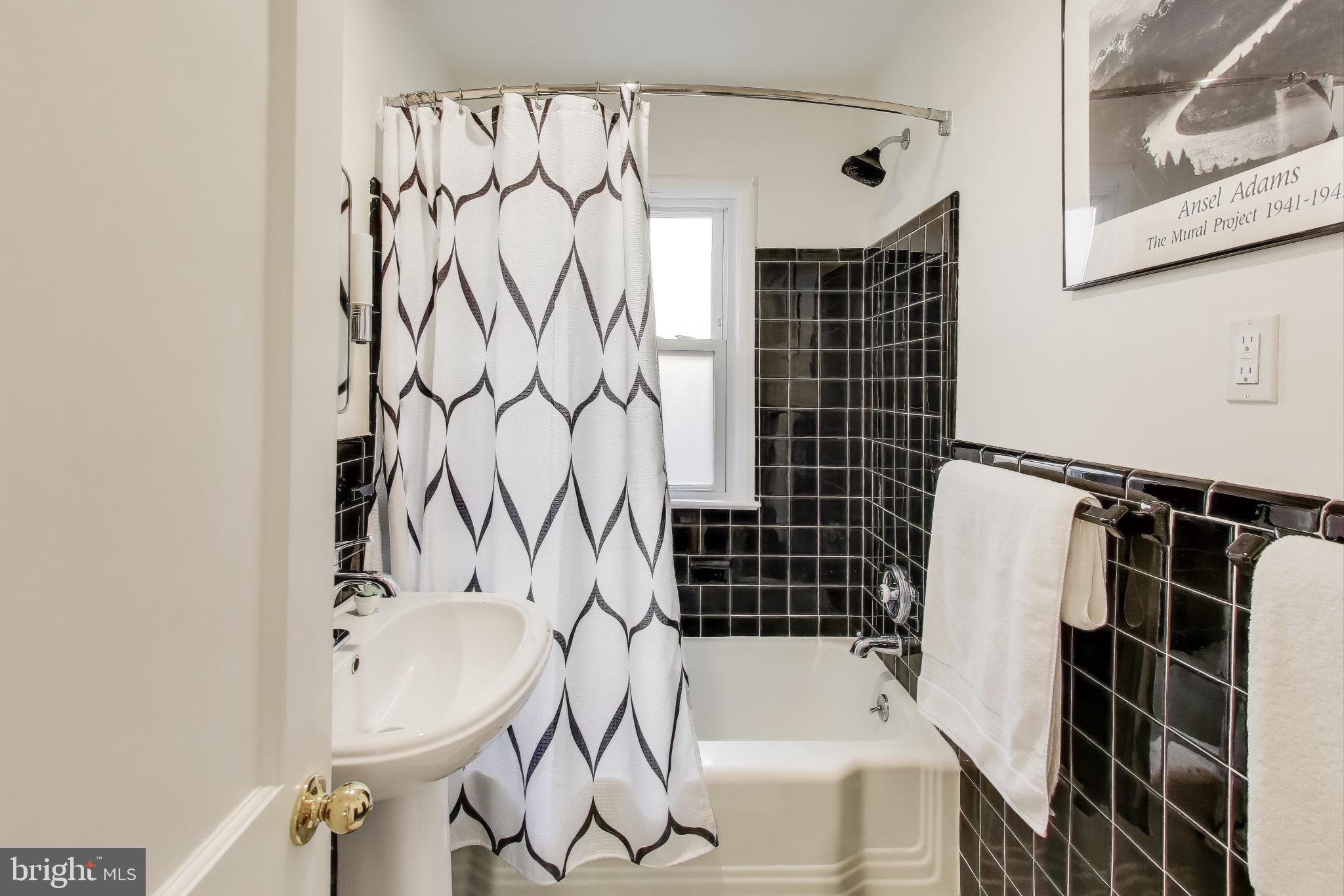 9613 Lorain Avenue Silver Spring, MD 20901 - Photo 25 of 40 a bathroom with a bathtub and shower