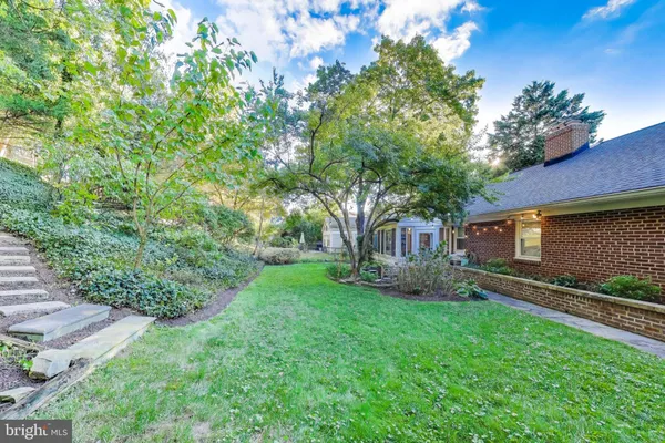 a view of a chair and table in backyard of the house