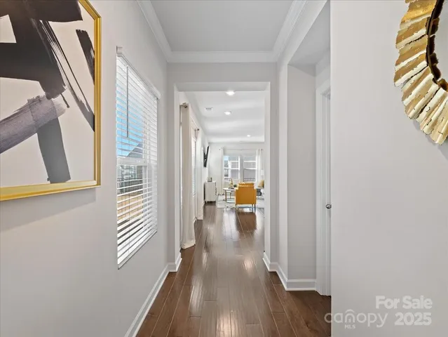 a view of a hallway with wooden floor and a living room