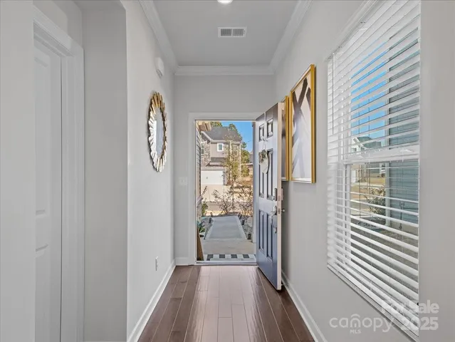 a view of a hallway with wooden floor and entryway