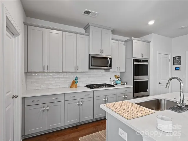 a kitchen with white cabinets and sink