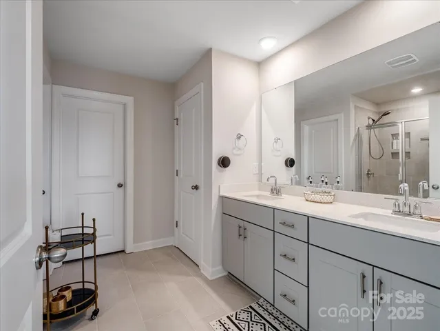 a spacious bathroom with a double vanity sink and a mirror