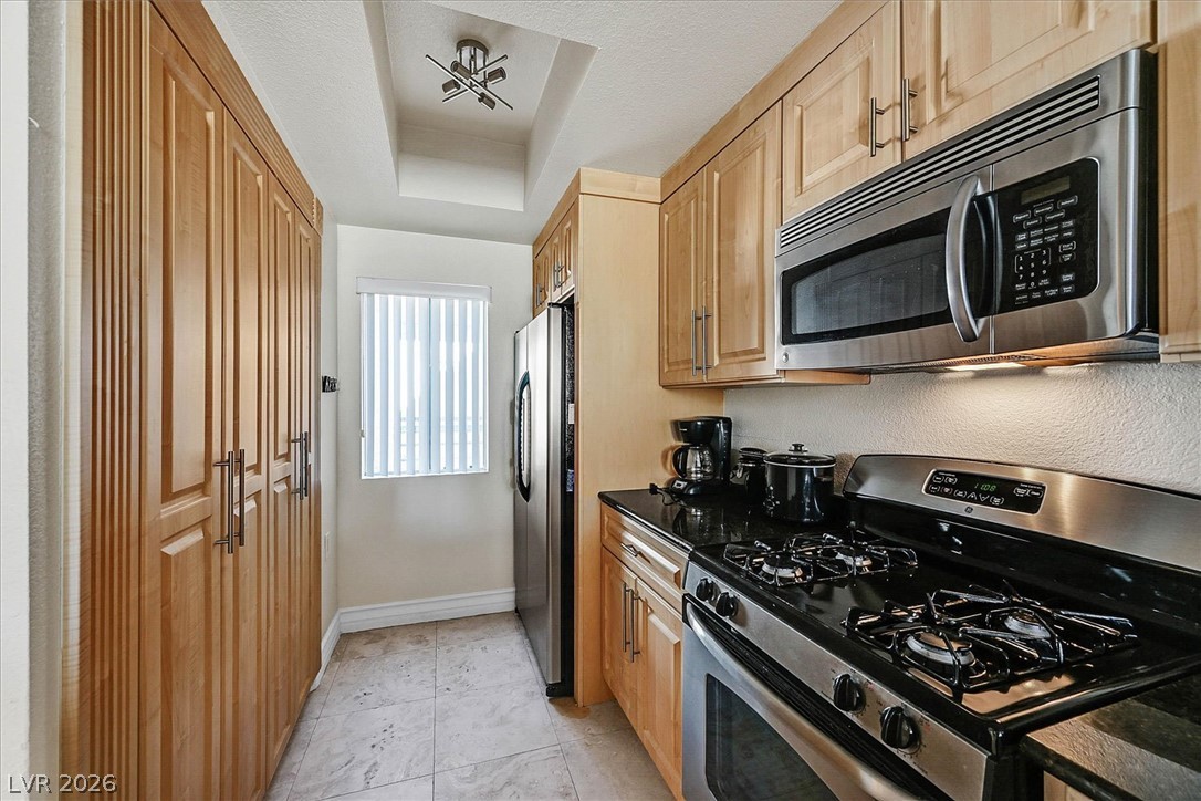 220 East Flamingo Road, Unit 305 Las Vegas, NV 89169 - Photo 4 of 26 A galley-style culinary space offers efficient stainless steel appliances and abundant cabinetry.