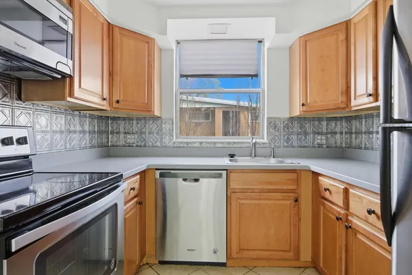 a kitchen with stainless steel appliances granite countertop a sink stove and cabinets