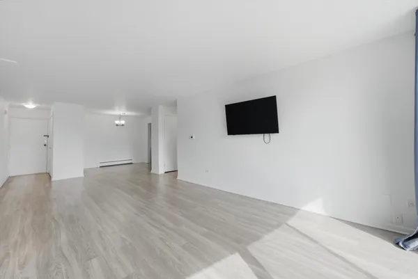a view of an empty room and wooden floor