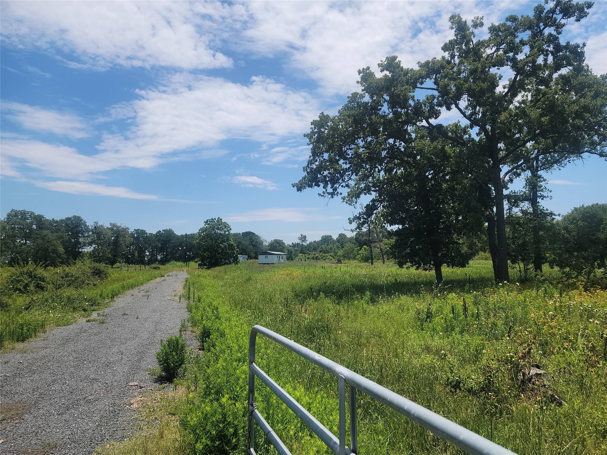 a view of a green field with wooden fence