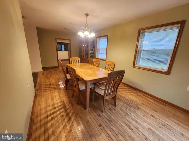 a dining room with furniture a chandelier and wooden floor