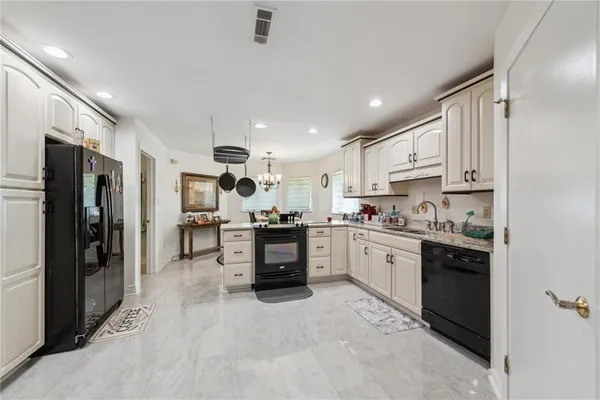 a kitchen with stainless steel appliances a stove refrigerator sink and microwave