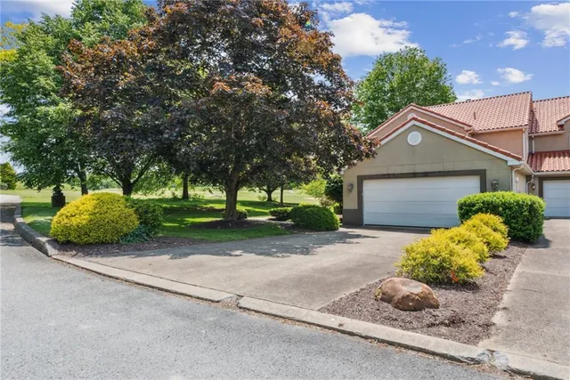 a front view of a house with a yard and a garage
