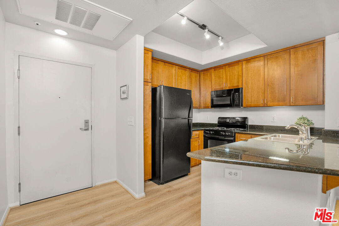 4060 Glencoe Avenue, Unit 228 Marina del Rey, CA 90292 - Photo 3 of 18 a kitchen with a refrigerator a stove a sink a center island and cabinets