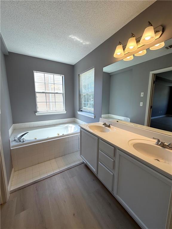 2205 Springer Walk Lawrenceville, GA 30043 - Photo 15 of 26 a spacious bathroom with a bathtub a sink and a vanity