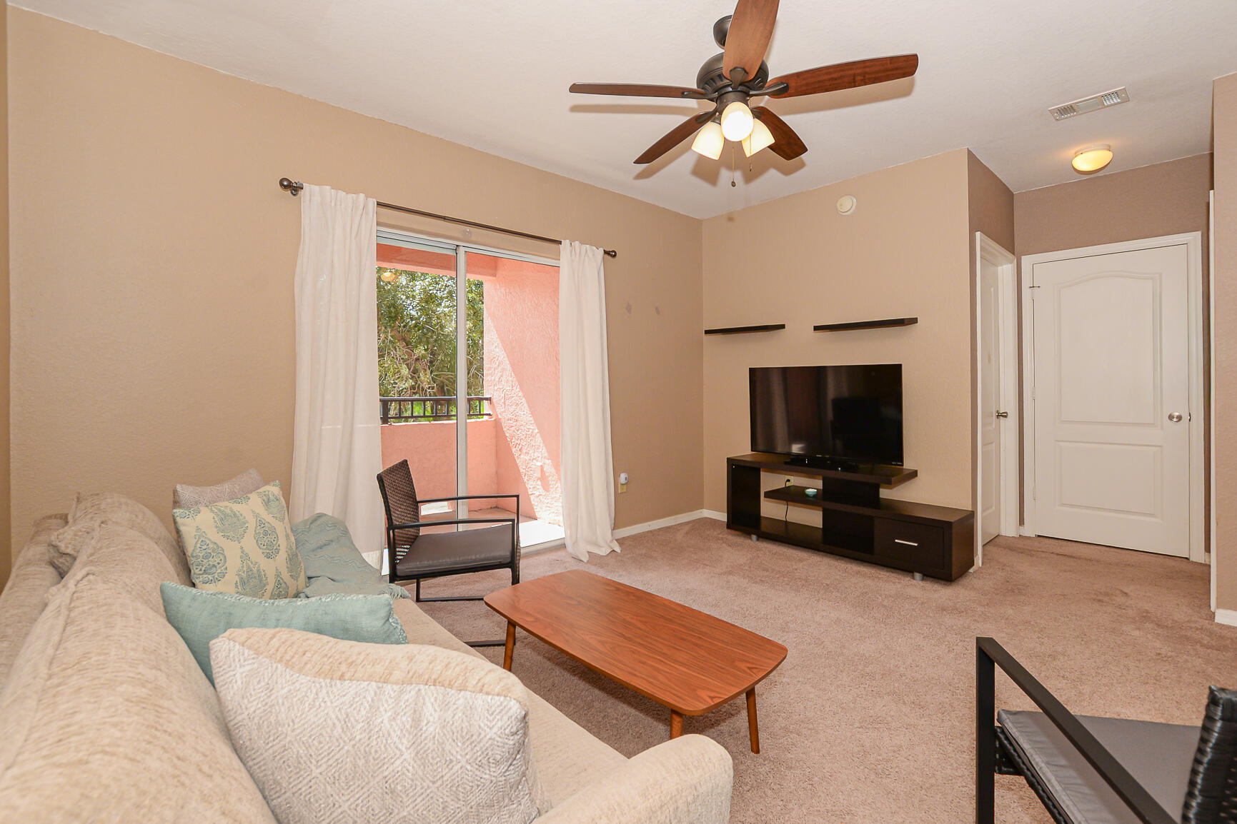 106 Southwest Peacock Boulevard, Unit 4204 Port St. Lucie, FL 34986 - Photo 18 of 46 a living room with furniture and a flat screen tv