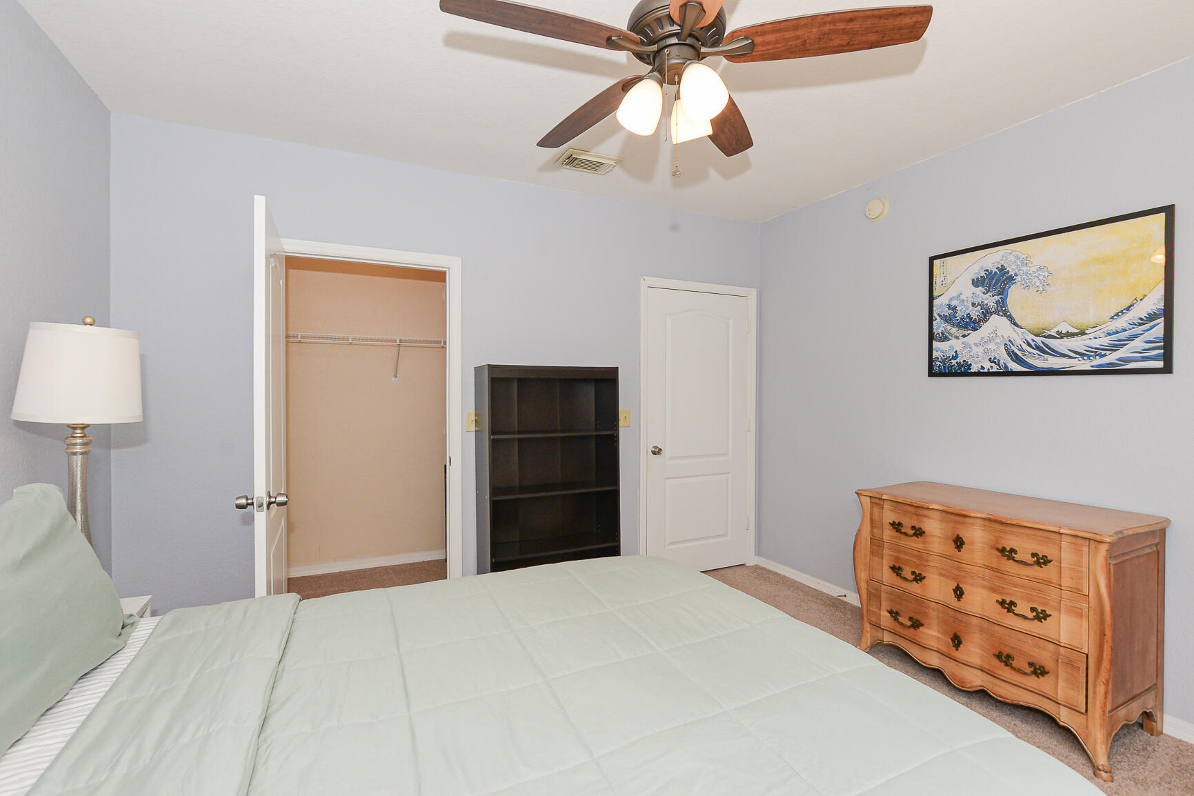 106 Southwest Peacock Boulevard, Unit 4204 Port St. Lucie, FL 34986 - Photo 23 of 46 a bedroom with a bed and a lamp on the dresser